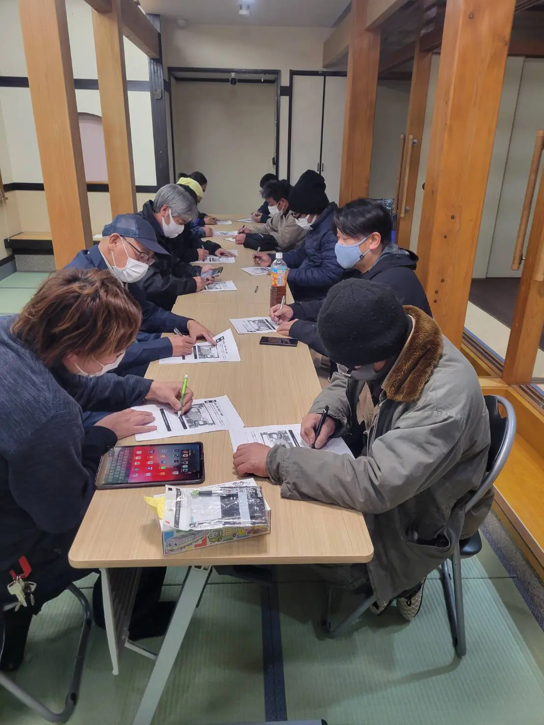 複数の人が日報を手書きで書いている画像