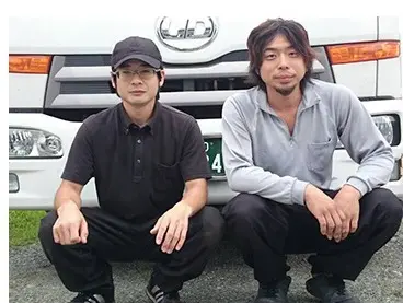 トラックの前でドライバーさんが座っている画像