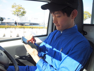 ドライバーがスマートフォンを触っている画像